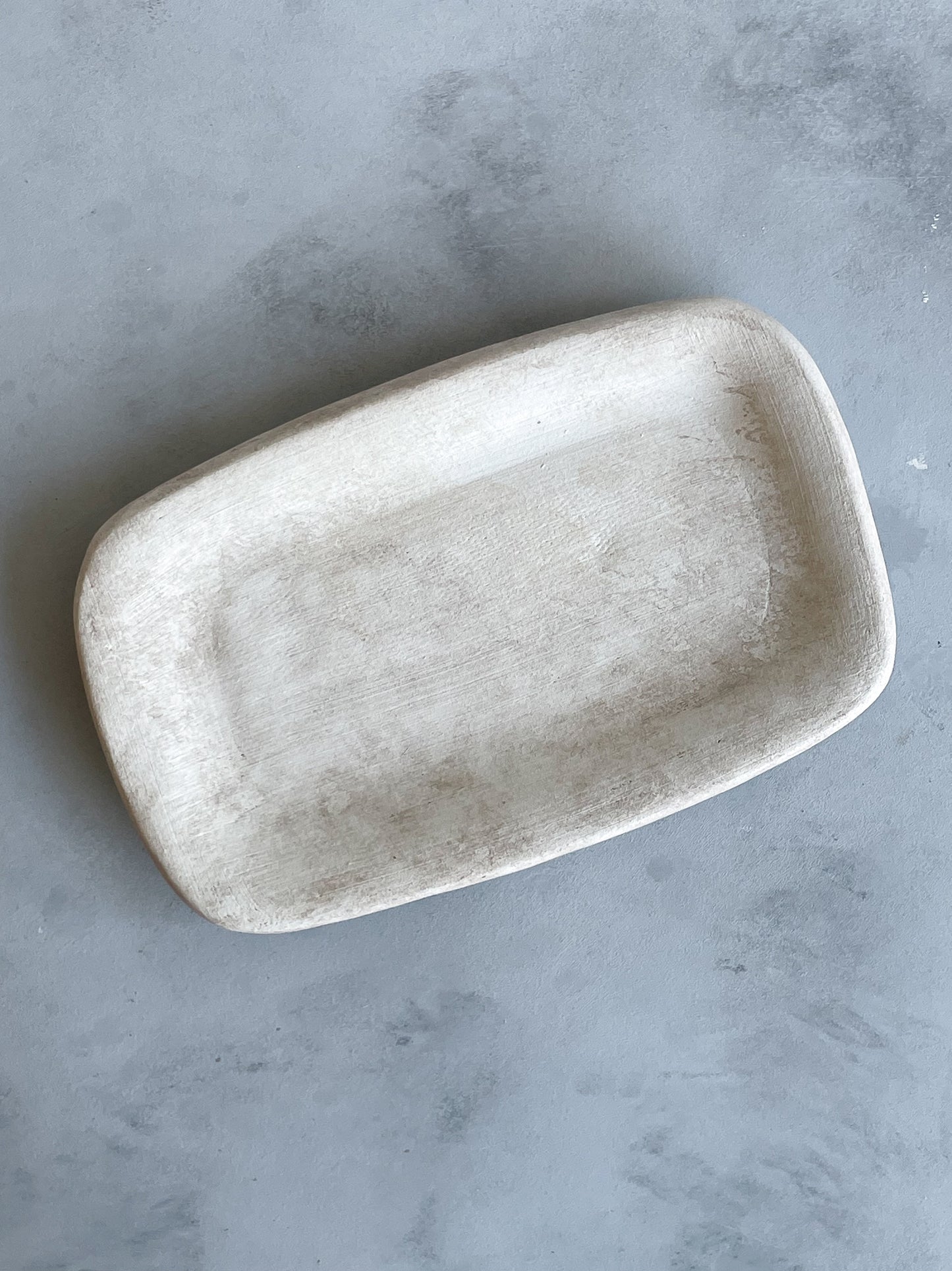 Close-up of Milos Collection handmade ceramic rustic tray showing textured surface and neutral tones.